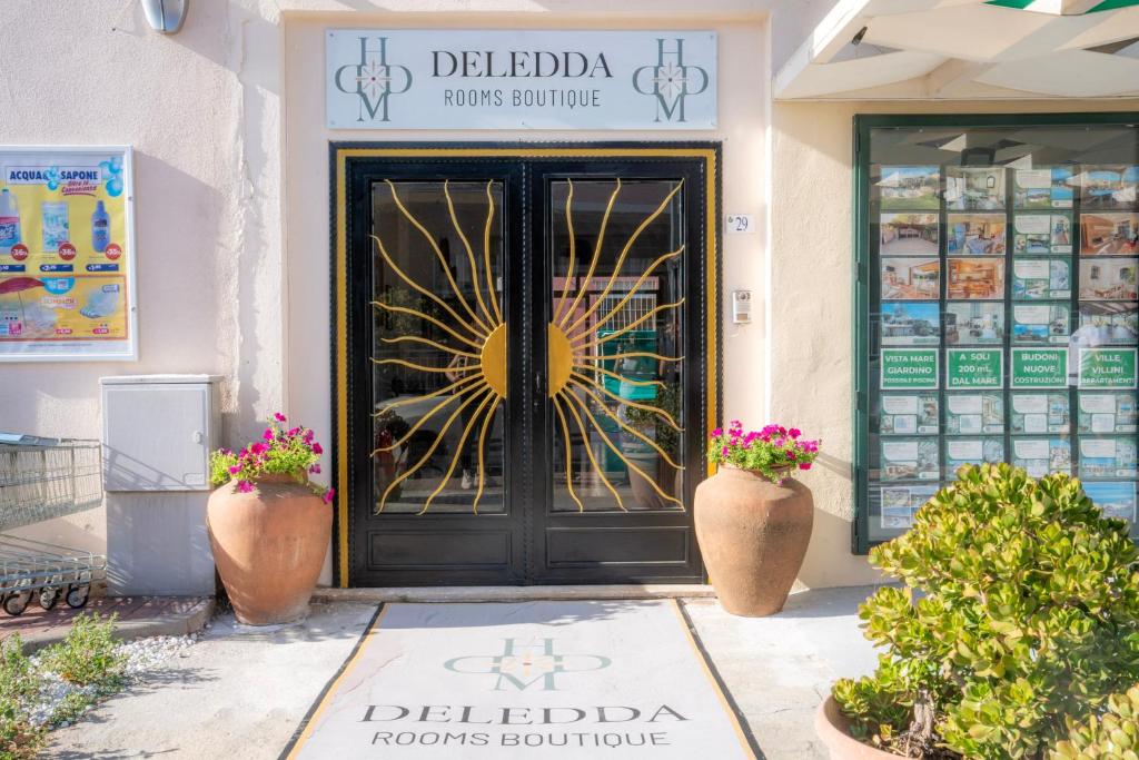 a front door of a store with two plants at Deledda Rooms Boutique in Budoni