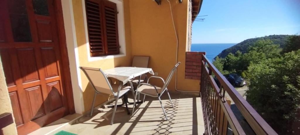 a balcony with a table and chairs and the ocean at Oasis - Oaza in Sutomore