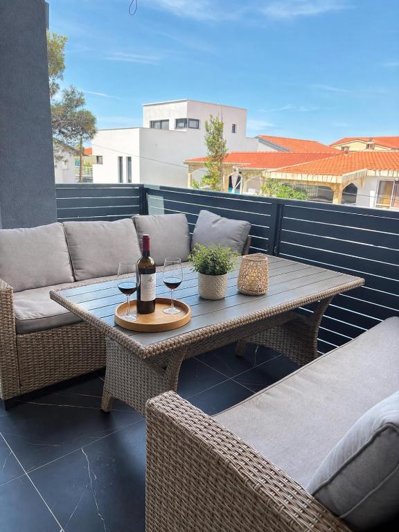a patio with a table with a bottle of wine at Apartmani Catakovic in Vir