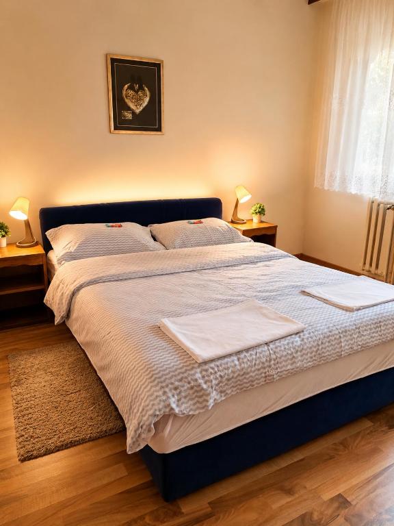 a bedroom with a large bed with two towels on it at Aura Apartment Sarajevo in Sarajevo