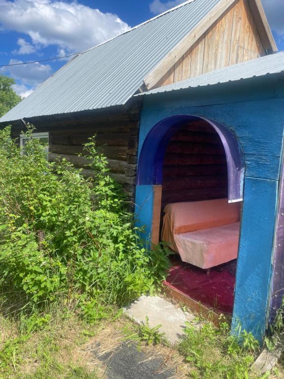 a blue dog house with a bed in it at Домики in Borovoye