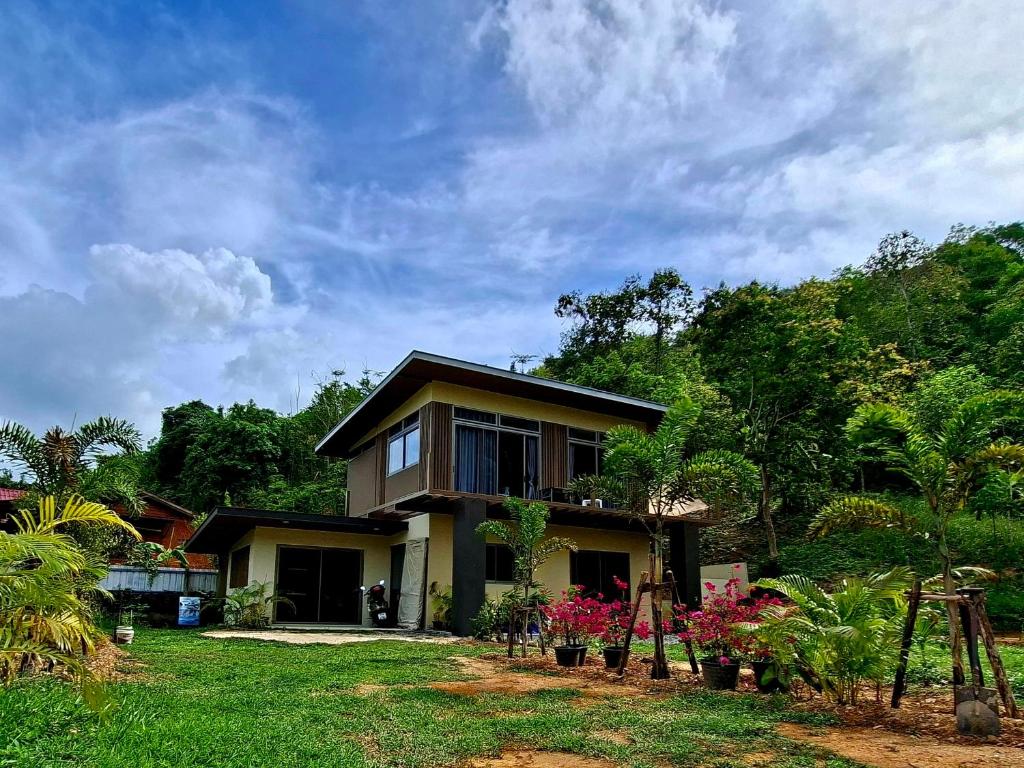 a house with a lot of plants in front of it at Tha Khao Beach House 1 in Ban Bang Chak
