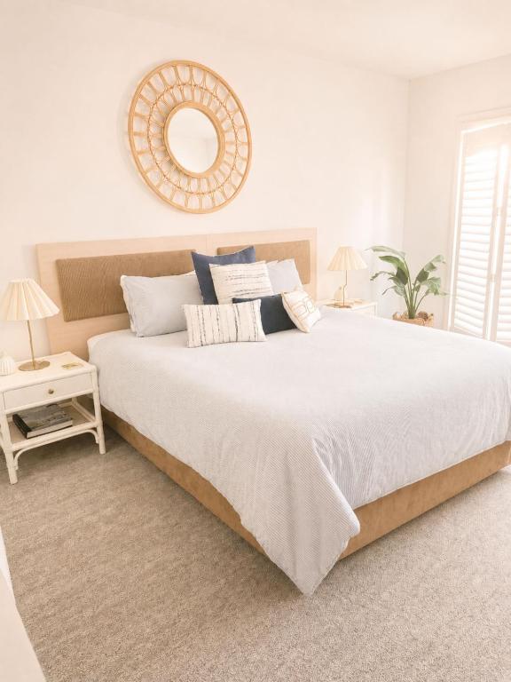 a white bedroom with a large bed and a mirror at Newly Restyled Resort Studio Oaks Pacific Blue in Salamander Bay