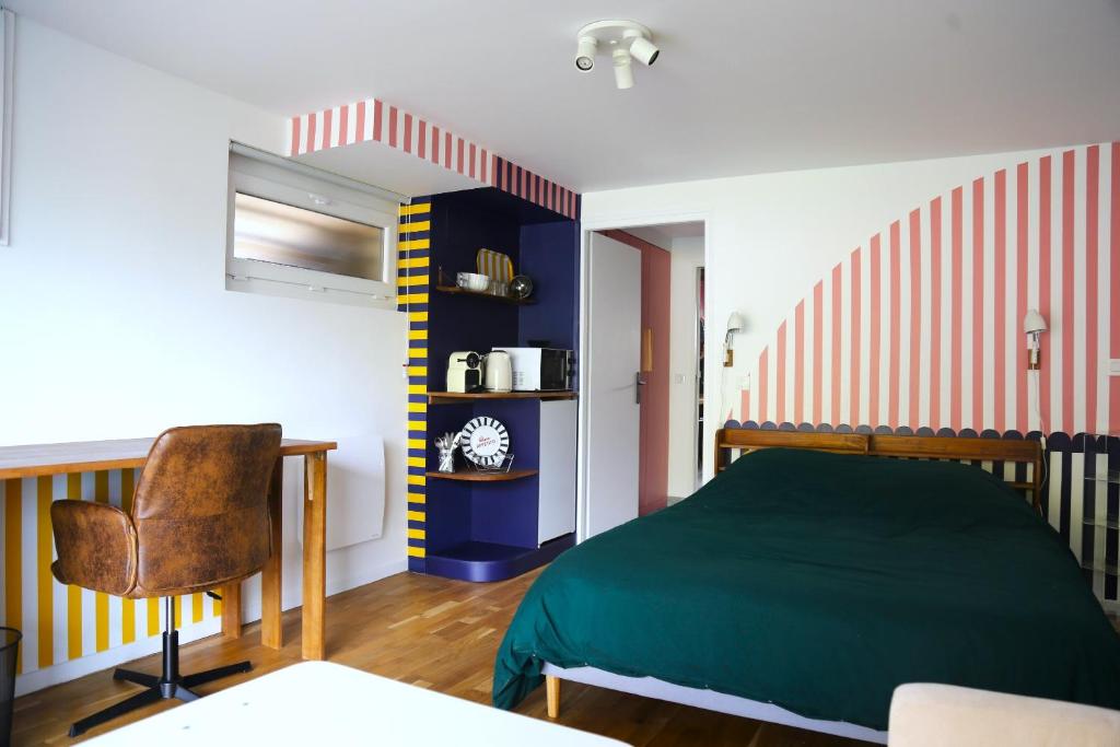 a bedroom with a green bed and a chair at Stripe Studio in Bonne-sur-Ménoge