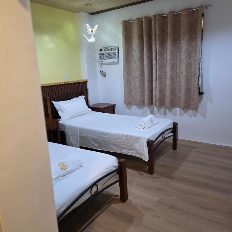 a small room with two beds and a window at Sunflower Residences Capitol formerly mayflower inn in Cebu City