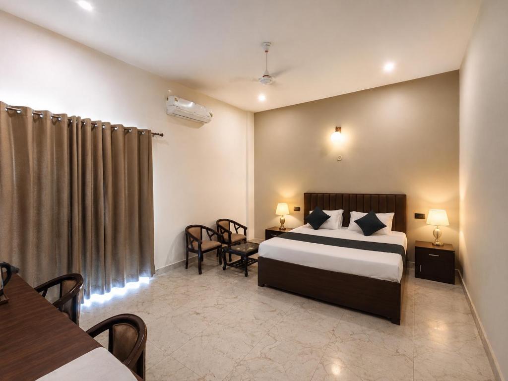 a hotel room with a bed and a table and chairs at Glotus Hotel in Herbertpur