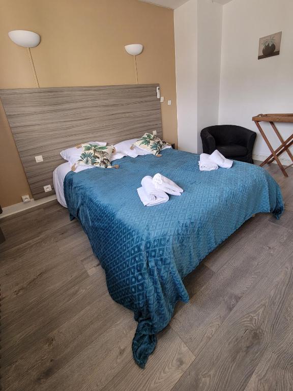 a bedroom with a blue bed with towels on it at Océan et Forêt in Les Mathes