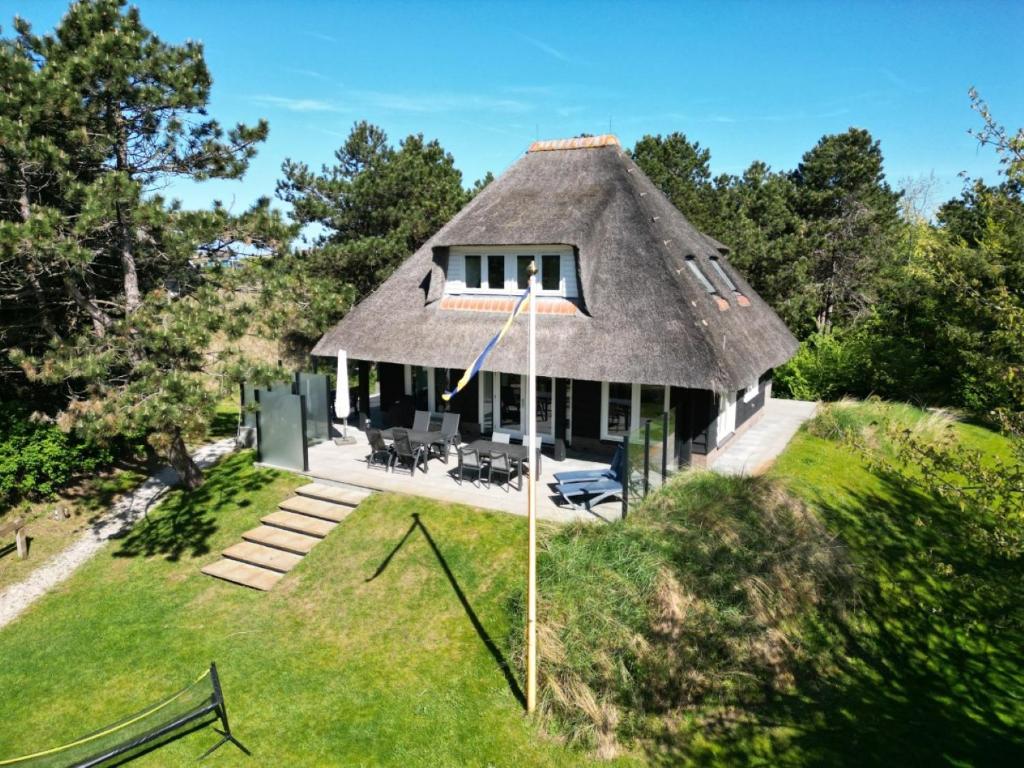 a house with a thatched roof on top of a field at Bosch (10p) in Buren