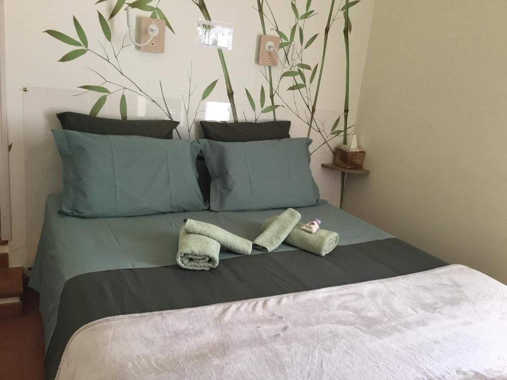 a bed with two towels and pillows on it at La Pierrerie Bambou in Tourtour