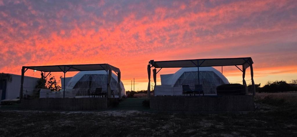 two white domes with a sunset in the background at Domes at the Beach in Maroni