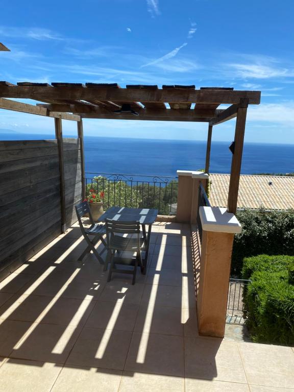 a patio with a table and chairs and the ocean at Studio in Brando