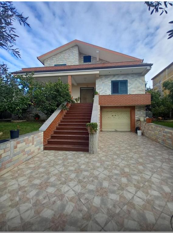 a house with a staircase and a garage at Vila Relax, Manez Durrës in Manzë