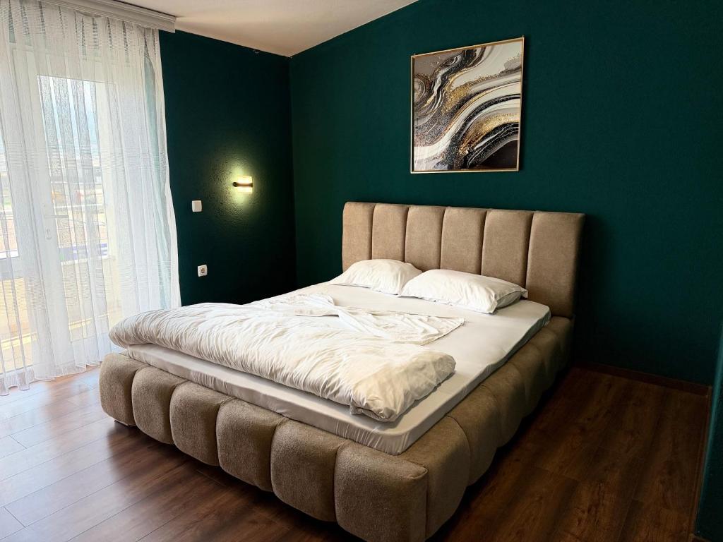a bed in a room with a green wall at Lindi Premium Hotel in Prizren