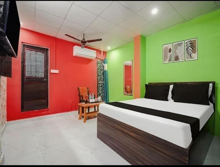 a bedroom with green and red walls and a bed at Hotel Pink City& Banquet in Dīgha