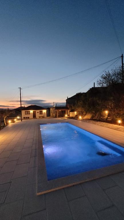a swimming pool in the middle of a yard at night at RECANTO da VONINHA in Castelo de Paiva