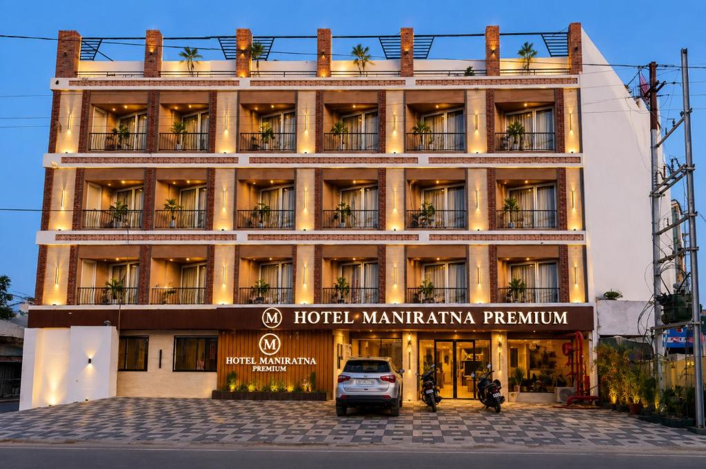 a hotel with a car parked in front of it at Hotel Maniratna Premium in Indore