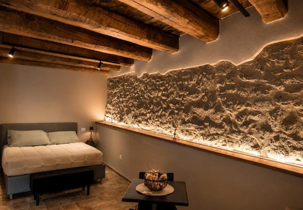 a bedroom with a bed and a stone wall at Casa Vacanze Partenzi in Vallo di Nera