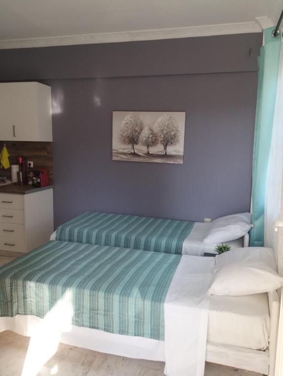 a bedroom with two beds and a painting on the wall at Αλέξανδρος 4 in Myrina