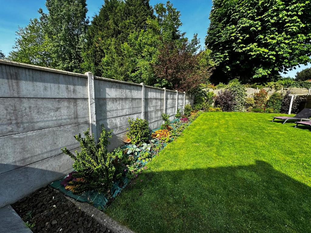 a garden with a fence and a grass yard at Gîte Autour d'Opale in Cucq