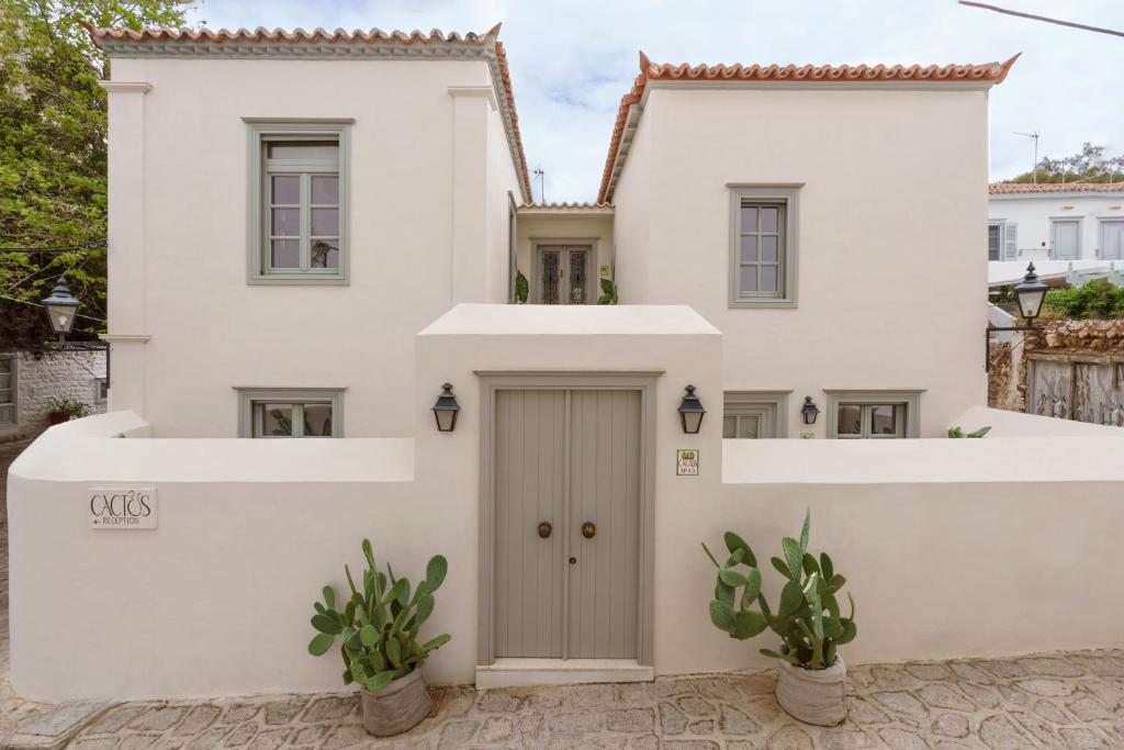 a white house with a door at Cactus Hydra - Art Apartments in Hydra