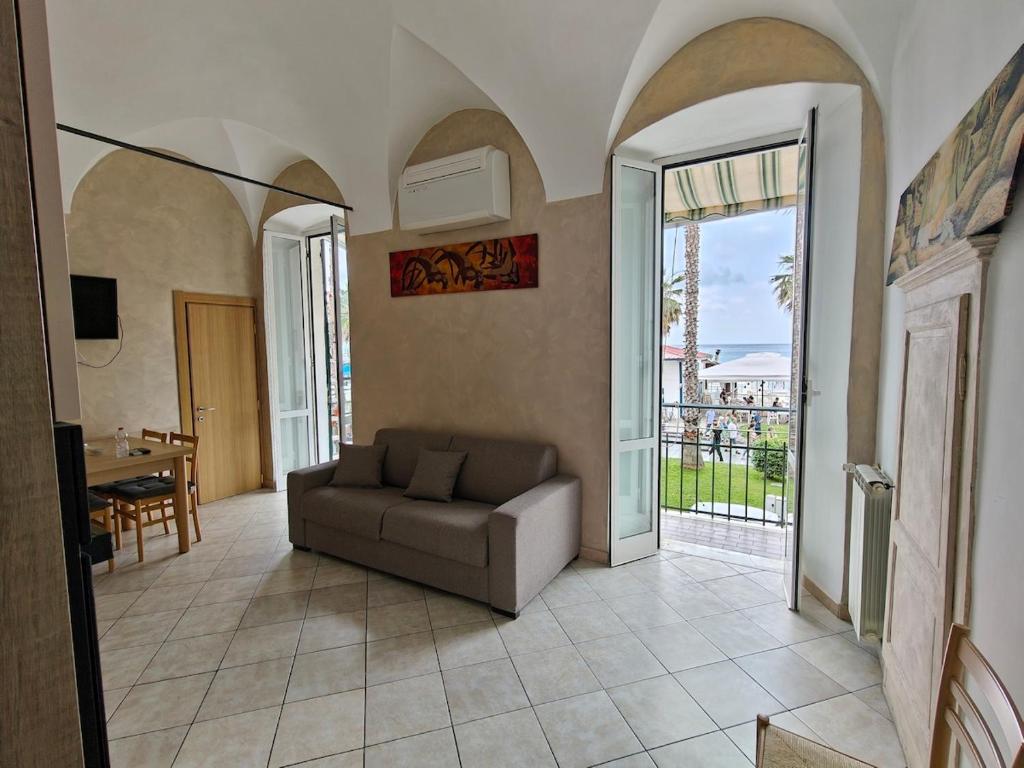 a living room with a couch and a balcony at Garibaldi 39 in Loano