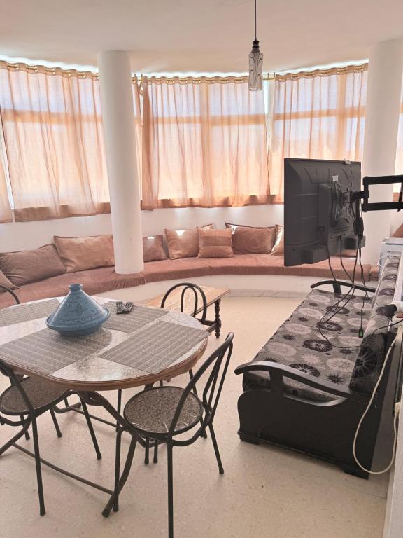 a living room with a table and a tv at Appartement de plage d in As Suwaysah