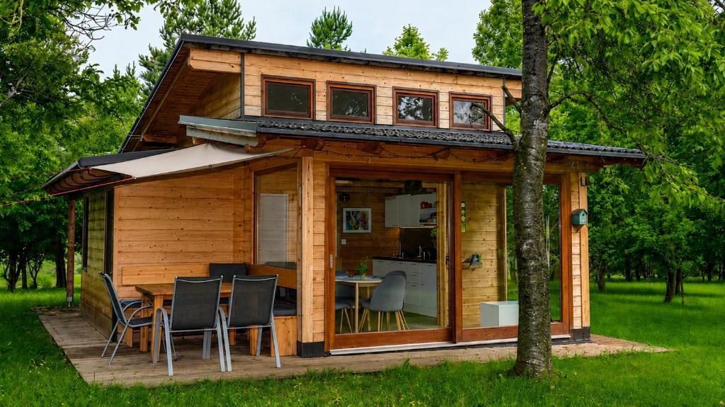 a log cabin with a table and chairs on a deck at Tiny House Grabovac in Rakovica