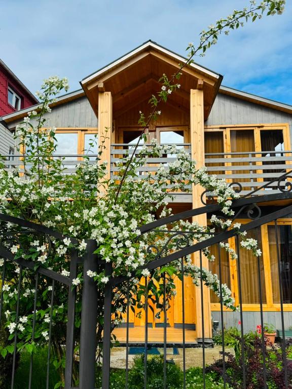 a house with a fence and flowers in front of it at Kobuleti Seaside Cottage in Kobuleti