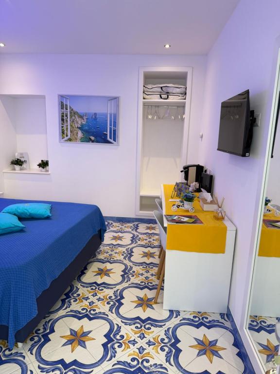 a room with a bed and a desk and a television at La Piccola Suite in Anacapri