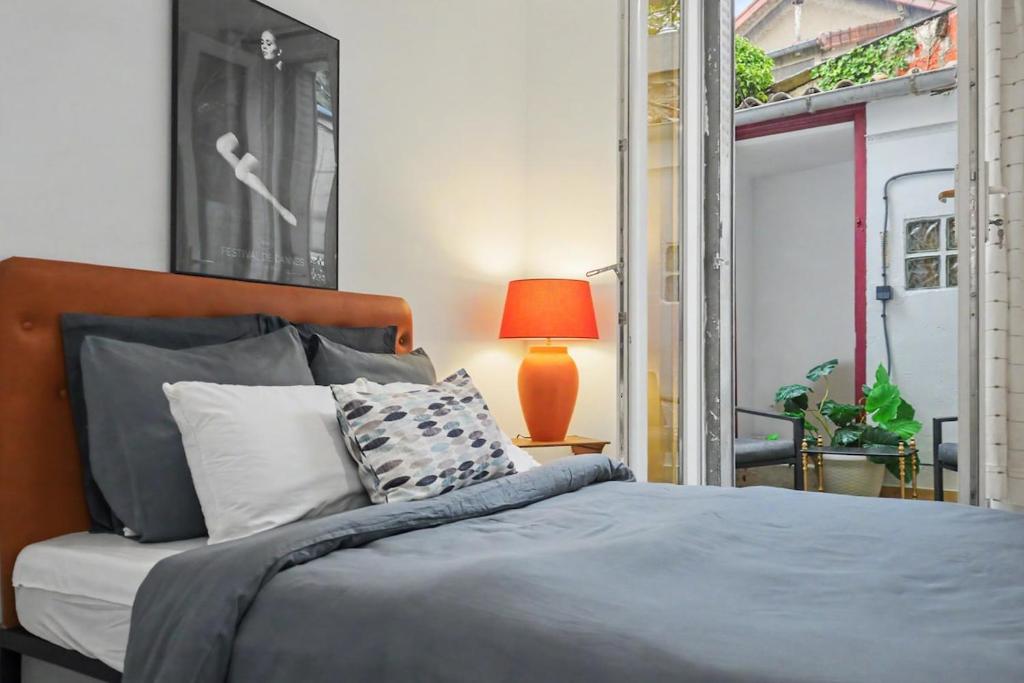 a bedroom with a bed and a lamp and a window at Lux PIGALLE in Argenteuil