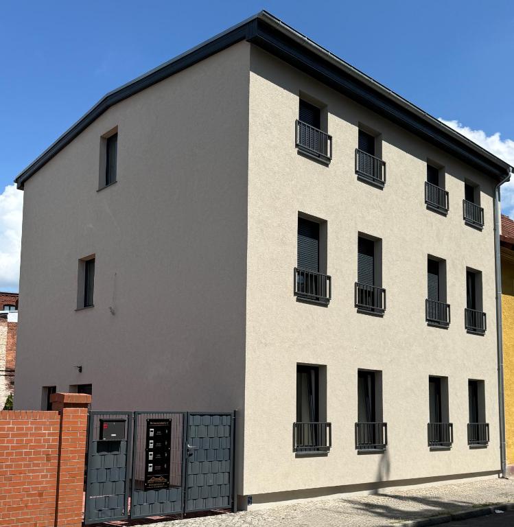 a white building with black windows and a fence at Ferienwelt Wittenberge in Wittenberge