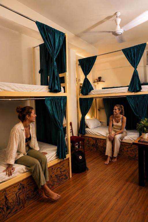 two people sitting on bunk beds in a room at Kashi Vibes Hostel in Varanasi