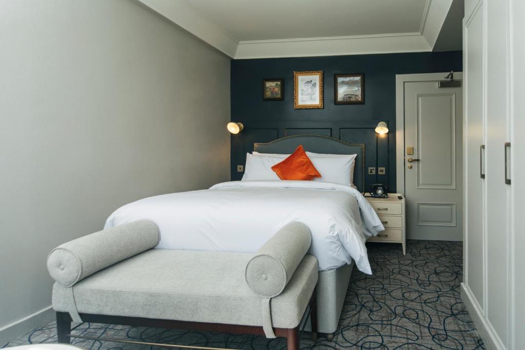 a bedroom with a large bed and a chair at The Lochalsh Hotel - Isle of Skye in Kyle of Lochalsh