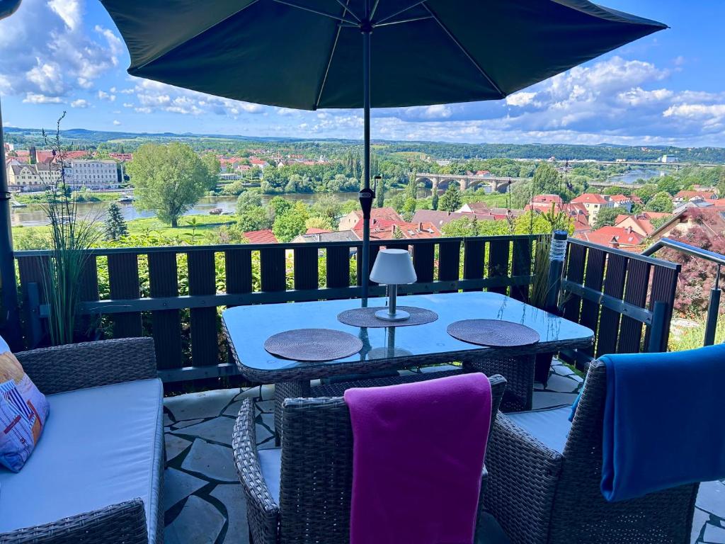 a patio with a table and chairs and an umbrella at Das Ferienhaus mit Aussicht in Pirna