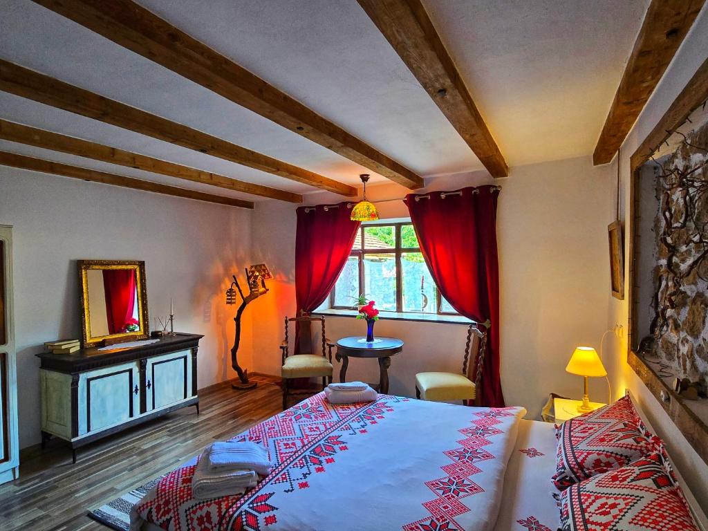 ein Schlafzimmer mit einem Bett, einem Tisch und einem Fenster in der Unterkunft CasaGeo Cheile Nerei in Socolari