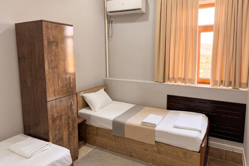 a small room with two beds and a mirror at BESQALA in Nukus