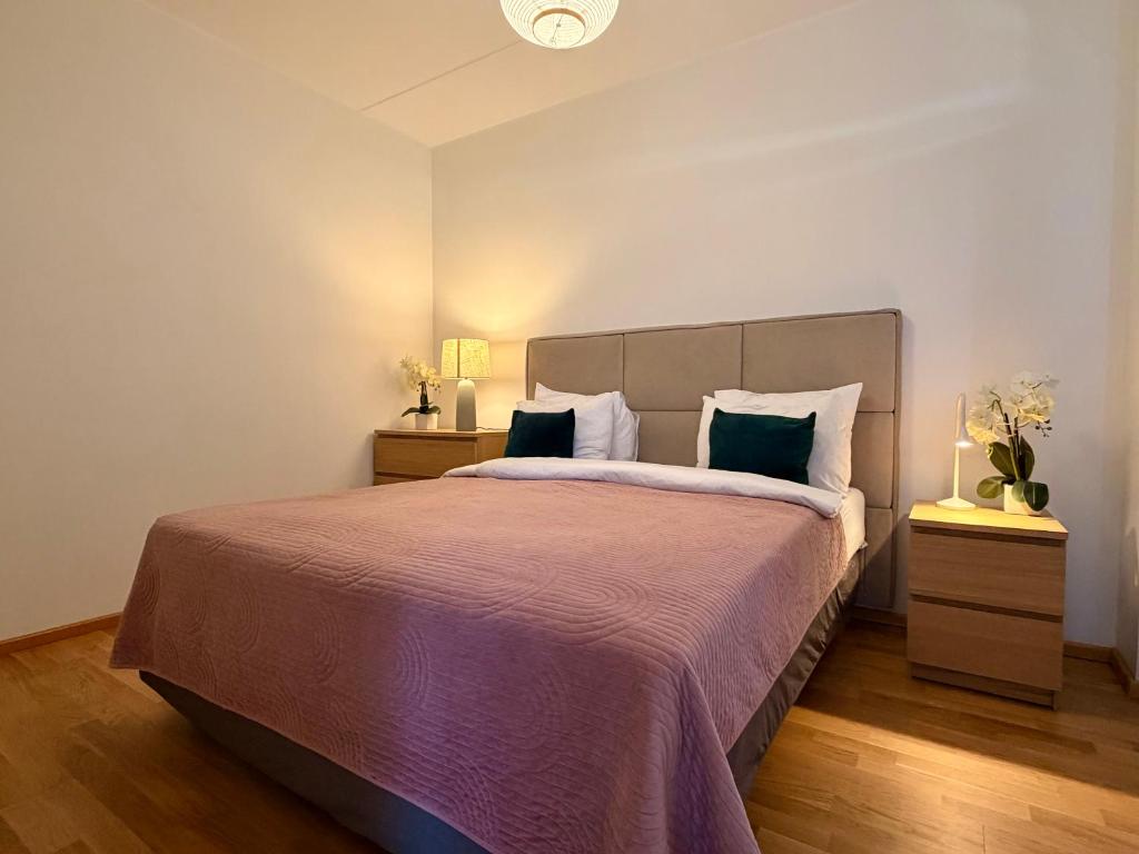 a bedroom with a large bed with a purple blanket at Luxury Suites Rotermanni 5 by Rikas Hotels in Tallinn