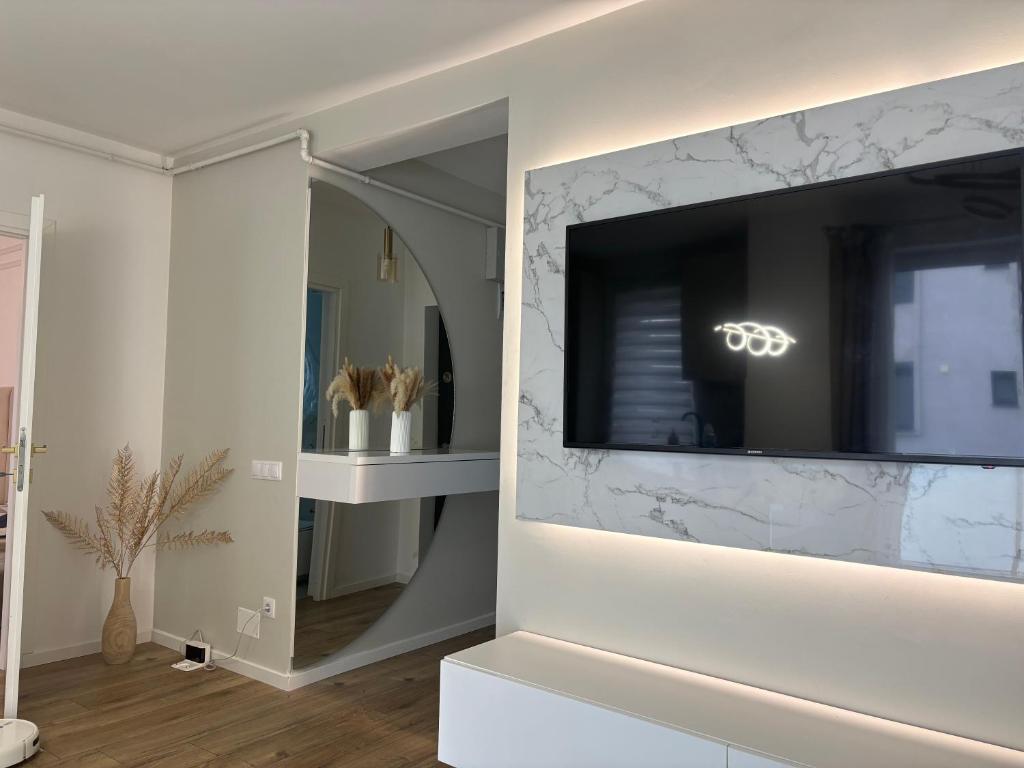 a living room with a television on a wall at Cosy luxury apartament in Baia Mare