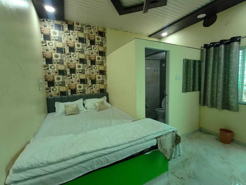 a bedroom with a bed and a wall with pictures at HOTEL o GUMTHI STAY INN in Patansaongi