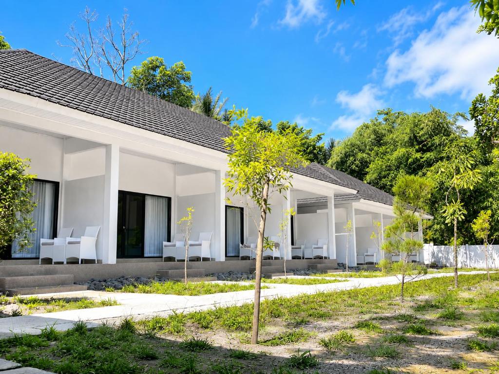a row of white villas with white chairs at Jou Trekking Guesthouse in Senaru