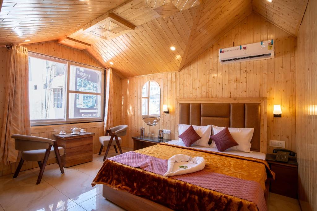 a bedroom with a large bed with a wooden ceiling at Royal Nest in Kasauli