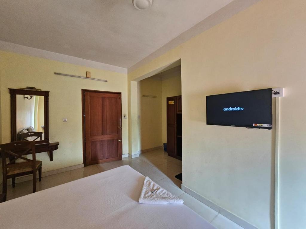 a bedroom with a bed with a flat screen tv on the wall at PTC Residency in Alleppey