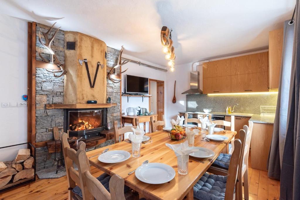 a dining room with a table and a fireplace at Chalet Firefly in Bansko