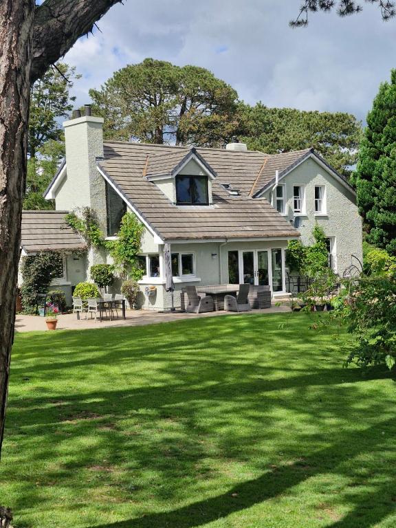 a house with a large yard with green grass at Drumee Lodge boutique B and B, Newcastle, County Down in Newcastle