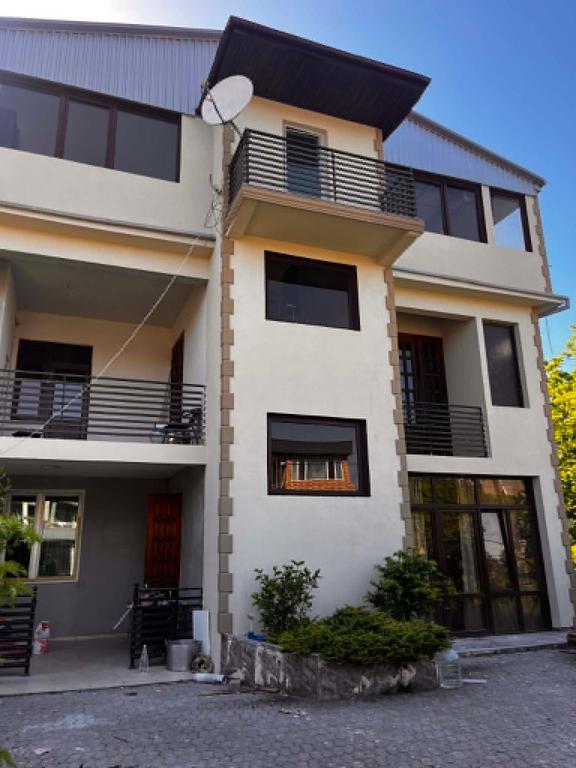 a large white building with windows and a balcony at Kobuleti stay inn in Kobuleti
