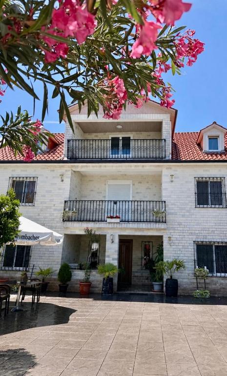 a building with a balcony and pink flowers at Villa Agos in Shkodër