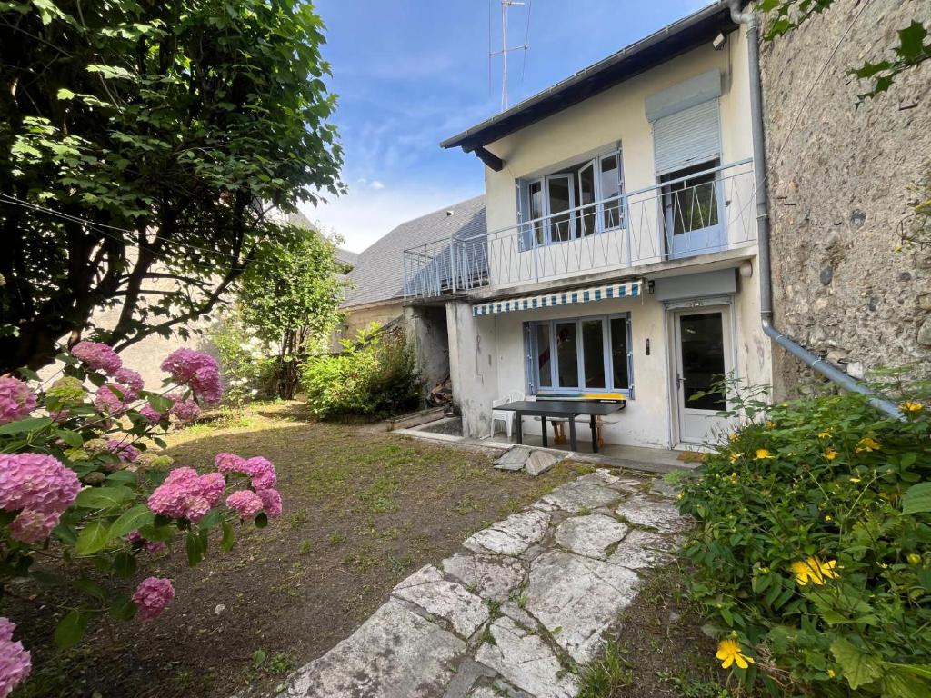 a house with a bench in a yard with flowers at Maison CALI LUZ in Luz-Saint-Sauveur