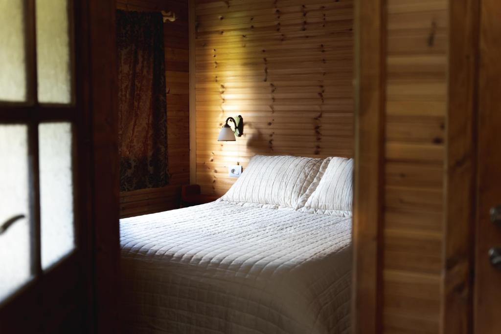 a bedroom with a bed with a wooden wall at Farma Sotira Agroturizem in Leskovik