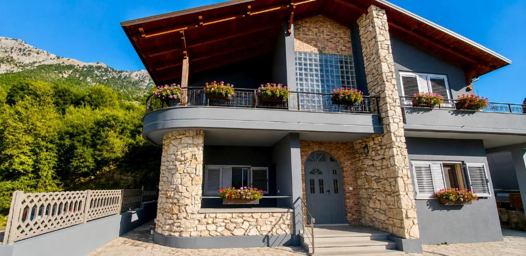 a building with flower boxes on the balcony at Countryside Villa in Vlorë