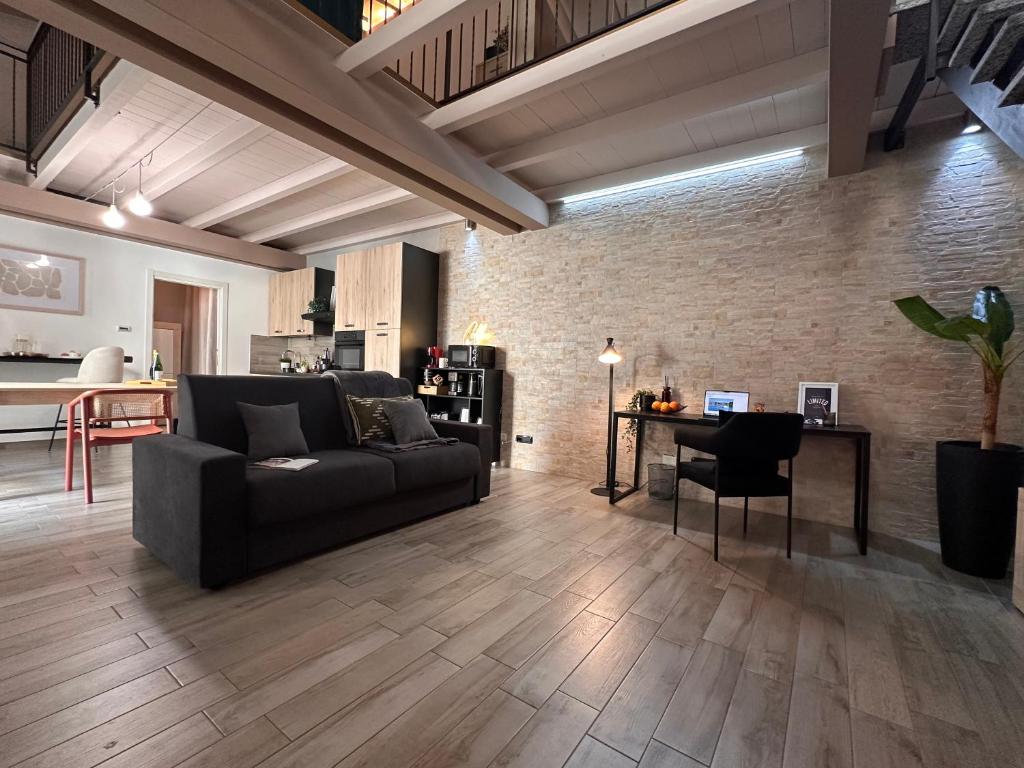 a living room with a couch and a table at The Hangar Loft - Leonoardo, Center & Parking in Sesto Calende